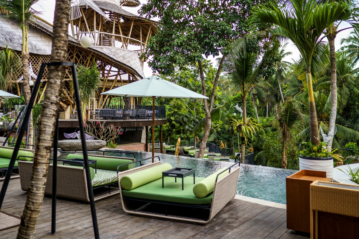 A deck featuring lounge chairs and umbrellas beside a sparkling pool, inviting relaxation and leisure.